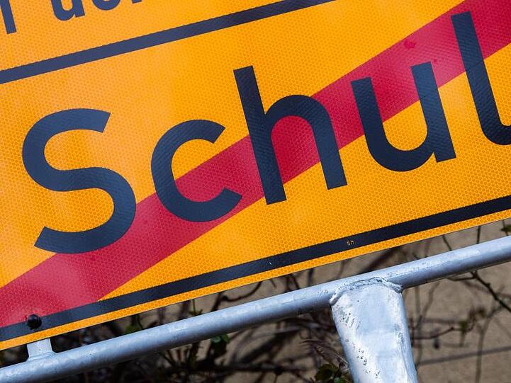 Ein Schild mit einem durchgestrichenen Schriftzug "Schule". Foto: Julian Stratenschulte/dpa/Symbolbild