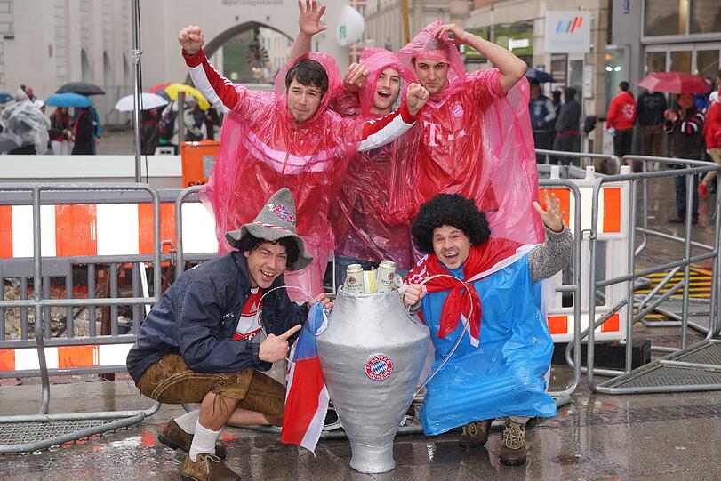 Das lange Warten auf die Pokalhelden. Es regnet und regnet und dennoch warten schon tausende Bayern-Fans auf das Eintreffen der Bayern-Stars. Die Bilder vom Marienplatz