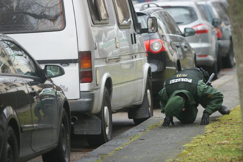 ... suchen unter parkenden Autos, ...
