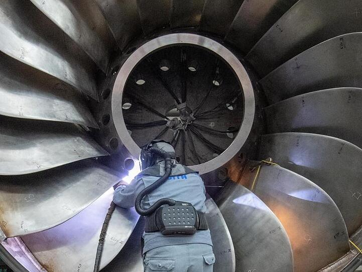 Ein Arbeiter eines Maschinen- und Anlagenbauers arbeitet an einer Wasserturbine.