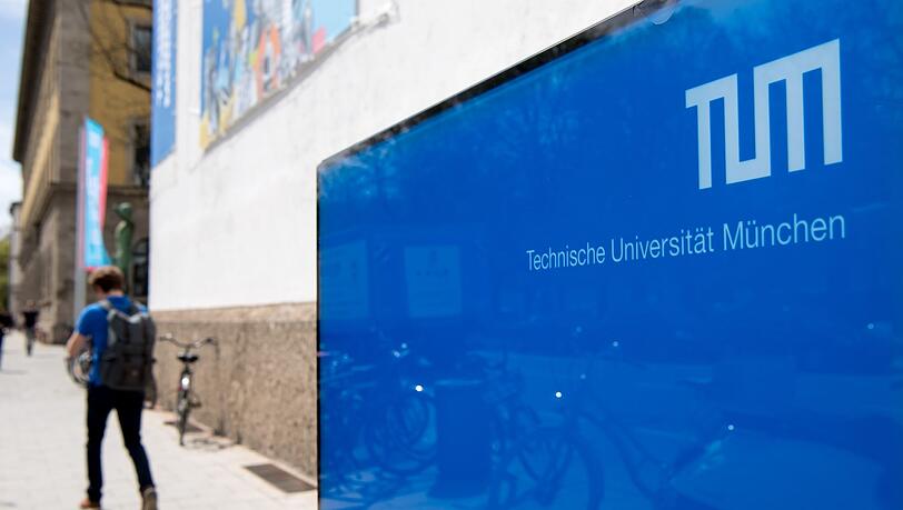 Ein Student geht vor dem Haupteingang der Technischen Universität München (TUM) entlang.