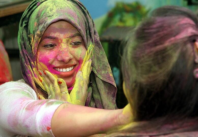 Die Menschen beschmieren sich von oben bis unten mit Farbe, aber besonders viel Spaß macht es, sich die Farbe gegenseitig im Gesicht zu verstreichen.
