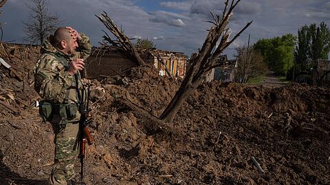 Ein ukrainischer Soldat inspiziert nach einem russischen Luftangriff in Bachmut das Terrain.