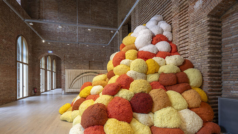 Sheila Hicks Riesenarbeit „Saffron Sentinel“ von 2017 macht sich ganz fabelhaft in den unverputzten Räumen von Schloss Herrenchiemsee. Dahinter sieht man ein weiteres Werk der 92-jährigen Künstlerin. Sheila Hicks Riesenarbeit „Saffron Sentinel“ von 2017 macht sich ganz fabelhaft in den unverputzten Räumen von Schloss Herrenchiemsee. Dahinter sieht man ein weiteres Werk der 92-jährigen Künstlerin.