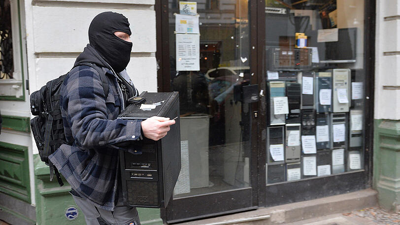 Polizeibeamte tragen am Mittwochvormittag sichergestellte Dinge in Kartons und Papiersäcken aus einem Haus in der Wittstocker Straße in Berlin Moabit