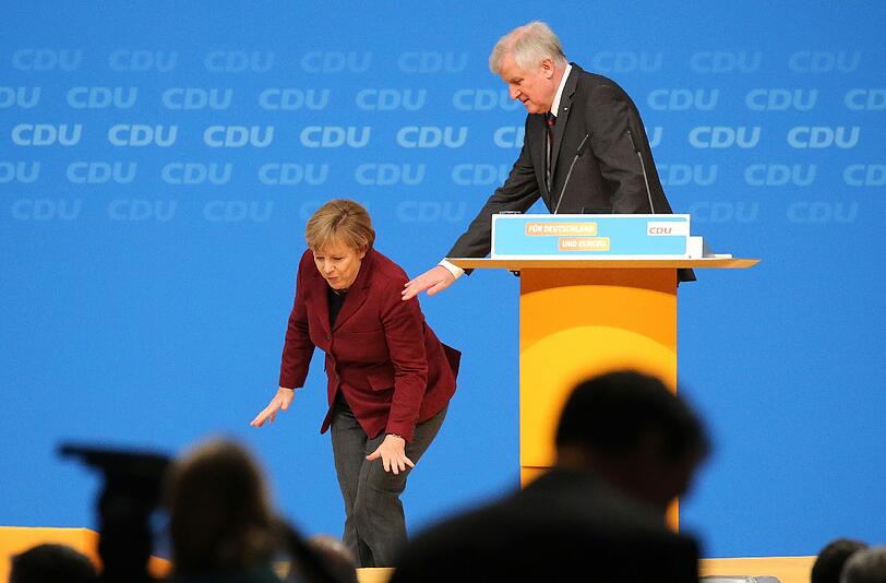 Nochmal gut gegangen: Bei der Verabschiedung von CSU-Chef Horst Seehofer nach dessen Rede auf dem CDU-Parteitag gerät Angela Merkel ins Stolpern &ndash; kann ihr Gleichgewicht aber noch halten.