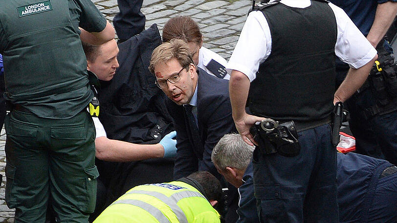 Der britische Parlamentsabgeordnete Tobias Ellwood (M) kümmert sich in der Nähe des britischen Parlaments nach dem Anschlag um verletzte Personen.