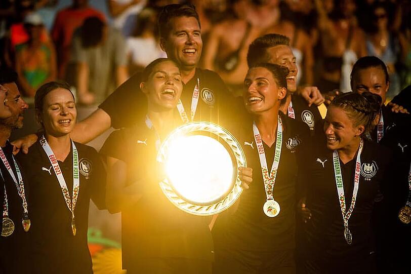 Der Moment des Triumphes: Nationaltrainer Alexander Novakovic (hinten Mitte) mit Physiotherapeutin  Franziska Stadler, Lucie-Marie Kretzschmar (Minga Turtles Ismaning; Tochter von Ex-Handball-Nationalspieler Stefan Kretzschmar; die EM-Trophäe in der Hand);  Amelie Bayerl (Brüder Ismaning), Kirsten Walter (Brüder Ismaning - vorne von links) sowie Co-Trainer Hendrik Sander (rechts neben Novakovic).