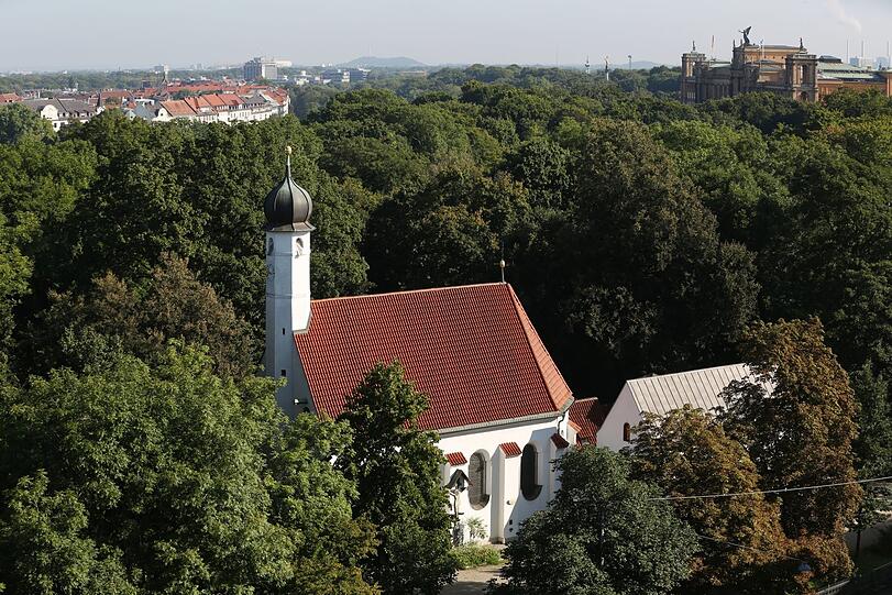 Mittendrin im Grün der Maximiliansanlagen: Die Kirche St. Nikolai (links) und die kleine Loretokapelle daneben - fotografiert vom Gasteigdach.