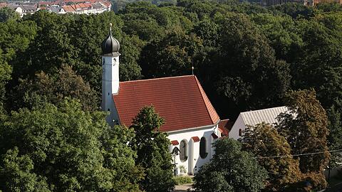 Mittendrin im Grün der Maximiliansanlagen: Die Kirche St. Nikolai (links) und die kleine Loretokapelle daneben - fotografiert vom Gasteigdach.
