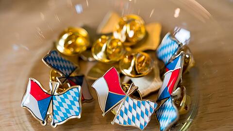 Anstecker mit den Fahnen Bayerns und der Tschechischen Republik liegen bei der Eröffnung der Bayerisch-Tschechischen Freundschaftswochen aus.