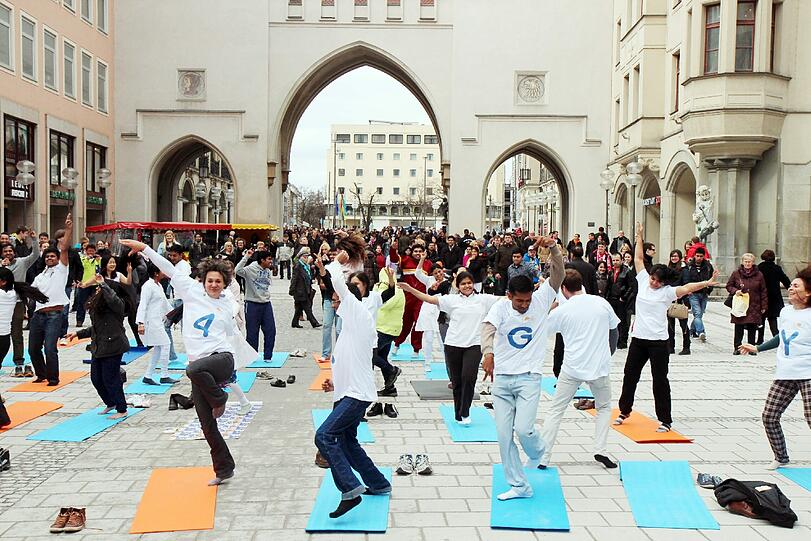 Hopsen und Dehnen in der Fußgängerzone: Am Stachus haben sich Yoga-Fans zu einem Flashmob unter freiem Himmel verabredet. Die Bilder.