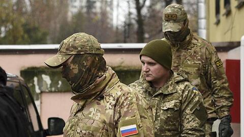 Ein ukrainischer Matrose (2.v.r.) wird von russischen Polizisten aus dem Gericht in Simferopol geleitet. 24 Seeleute sitzen derzeit in Untersuchungshaft.