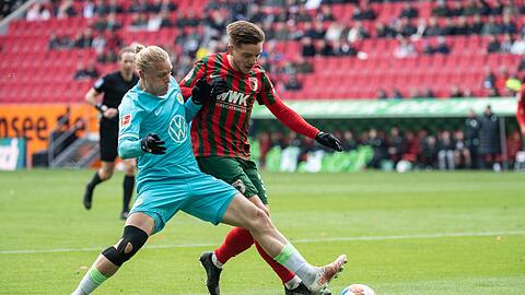 Xaver Schlager vom VfL Wolfsburg (l) und Mads Pedersen von Augsburg im Zweikampf um den Ball.