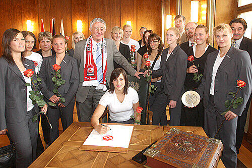 Autogramm von der Frau Kapitän: Ania Rösler mit den Club-Handballerinas bei Bürgermeister Horst Förther (mit Fanschal) im Rathaus.