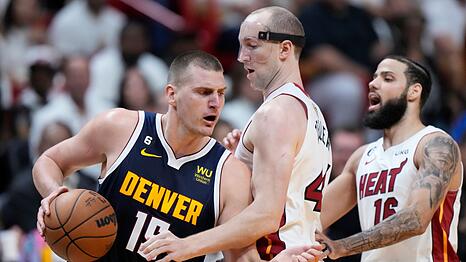Denver Nuggets-Center Nikola Jokic (l) dribbelt an Miami Heat-Center Cody Zeller vorbei.