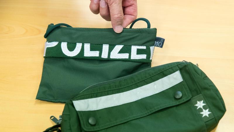 Ein Brustbeutel und eine Fahrrad-Lenkertasche gefertigt aus Stoffen alter Polizei-Uniformen liegen auf einem Tisch. Foto: Daniel Karmann Ein Brustbeutel und eine Fahrrad-Lenkertasche gefertigt aus Stoffen alter Polizei-Uniformen liegen auf einem Tisch. Foto: Daniel Karmann