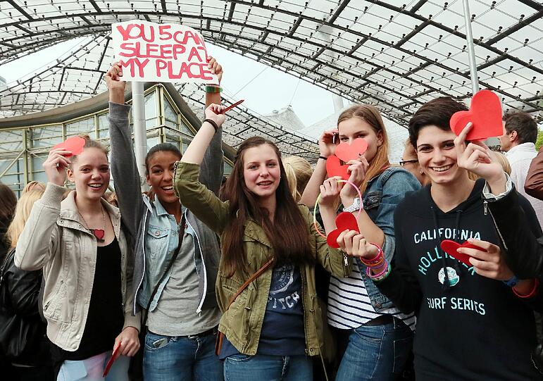 "One Direction" spielen am Freitag in der Olympiahalle. Jubelnde Fans warten im Regen vor der Olympiahalle.