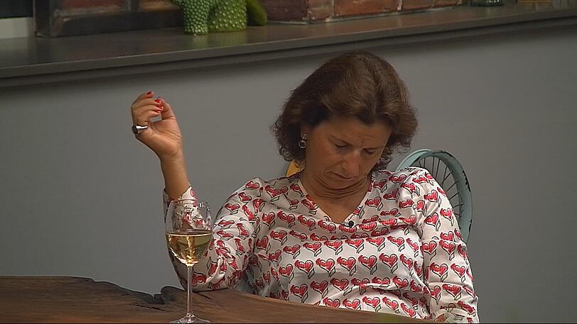 Eine alkoholisierte Claudia Obert schläft am Tisch ein