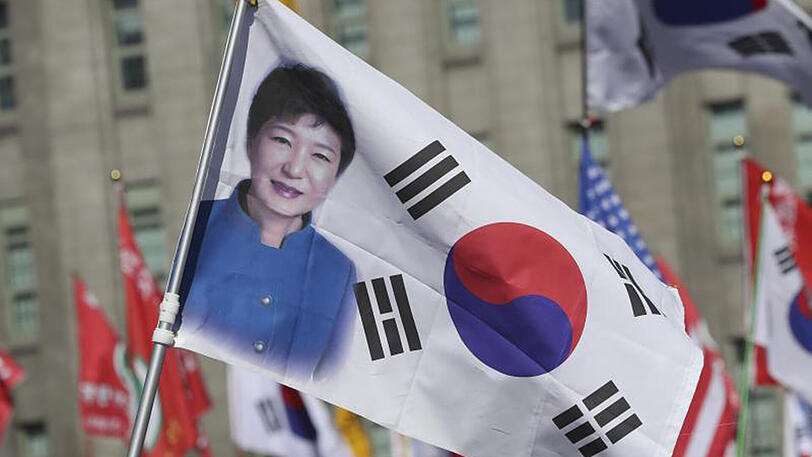 Teilnehmer einer Demonstration halten in Seoul eine Flagge mit einem Porträt von Präsidentin Park Geun Hye.