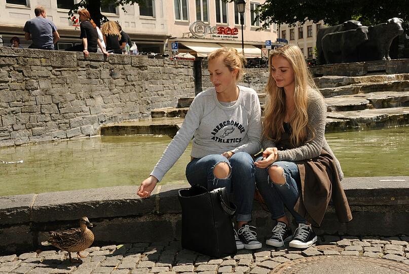 Draußen auf den Stufen genossen viele Münchner die ersten Sonnenstrahlen nach dem Regen.