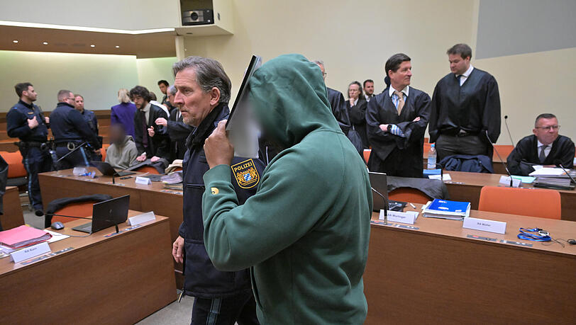Ein mutmaßliches Mitglied der nigerianischen Mafia wird zu Prozessauftakt in den Gerichtssaal gebracht.