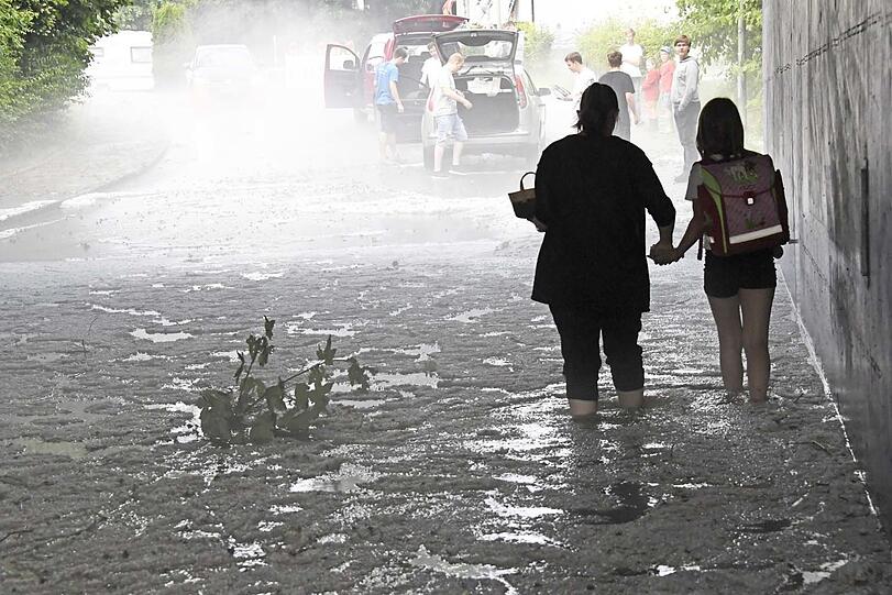 In Kirchseeon (Landkreis Ebersberg) waten Menschen durch Eiswasser.