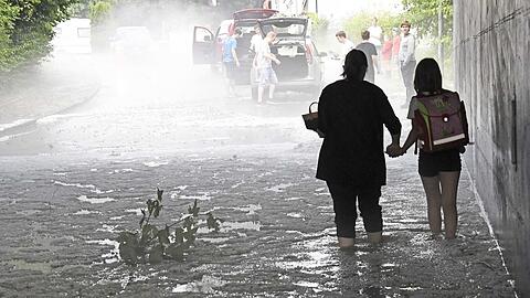 In Kirchseeon (Landkreis Ebersberg) waten Menschen durch Eiswasser.