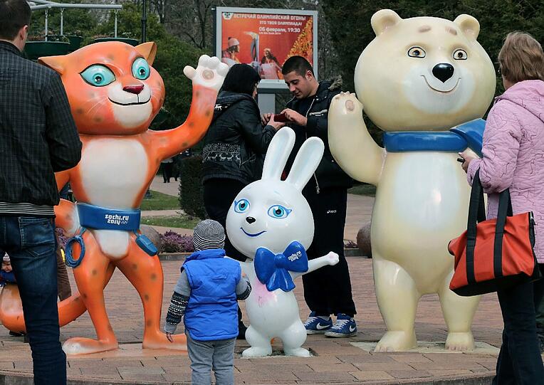 Maskottchen begrüßen die olympische Familie.