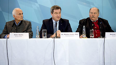Ministerpräsident Markus Söder (Mitte) spricht ein Machtwort, die Bürgermeister Peter Stehle (l., Obermaiselstein) und Konrad Kienle (Balderschwang) ziehen mit. Nach einem Treffen in der Staatskanzlei geben sie das vorläufige Aus der Skischaukel sowie die weiteren Entwicklungspläne bekannt.