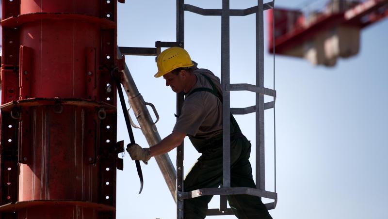 Ein Arbeiter montiert an einem Kran. Foto: Alexander Heinl/Archivbild