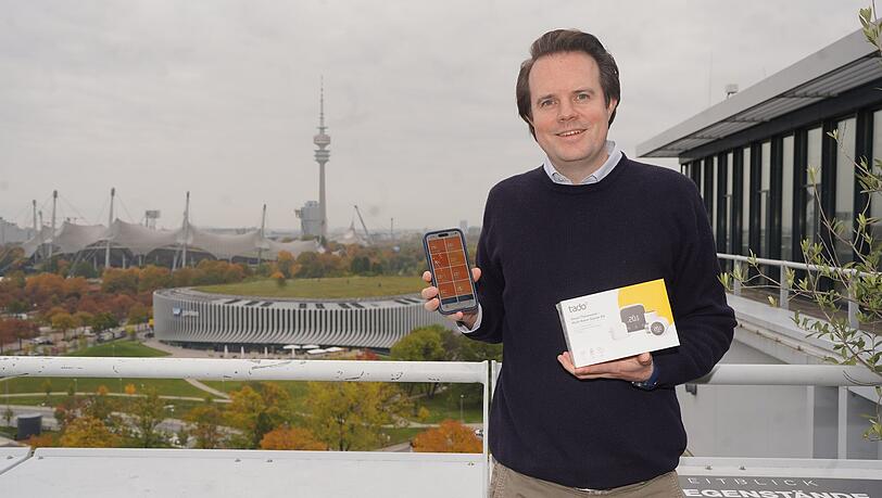 Christian Deilmann auf der Dachterrasse seines Münchner Firmensitzes am Sapporobogen. In seiner Hand: das Starter-Kit seiner KI-Heizregler samt App-Anwendung. Sie können eine erhebliche Menge CO2 einsparen, sagt Deilmann. Christian Deilmann auf der Dachterrasse seines Münchner Firmensitzes am Sapporobogen. In seiner Hand: das Starter-Kit seiner KI-Heizregler samt App-Anwendung. Sie können eine erhebliche Menge CO2 einsparen, sagt Deilmann.