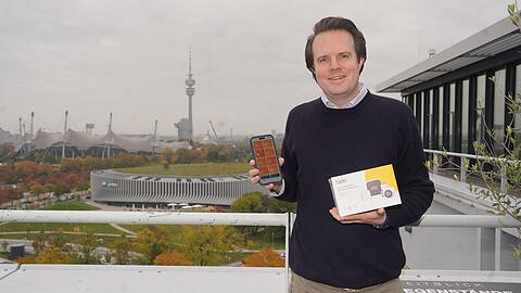 Christian Deilmann auf der Dachterrasse seines Münchner Firmensitzes am Sapporobogen. In seiner Hand: das Starter-Kit seiner KI-Heizregler samt App-Anwendung. Sie können eine erhebliche Menge CO2 einsparen, sagt Deilmann.