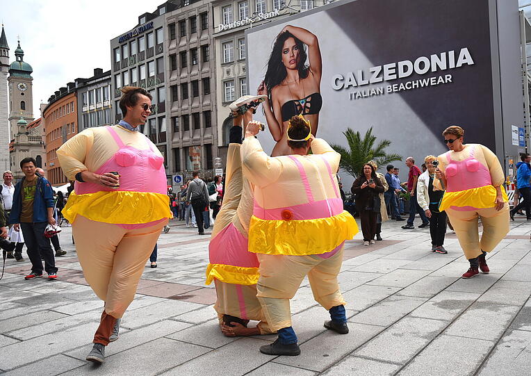 Am Ende werden sie zum Fotomotiv: Passanten scharen sich um die Junggesellen, die sich vor der Calzedonia-Werbung am Marienplatz prächtig amüsieren.