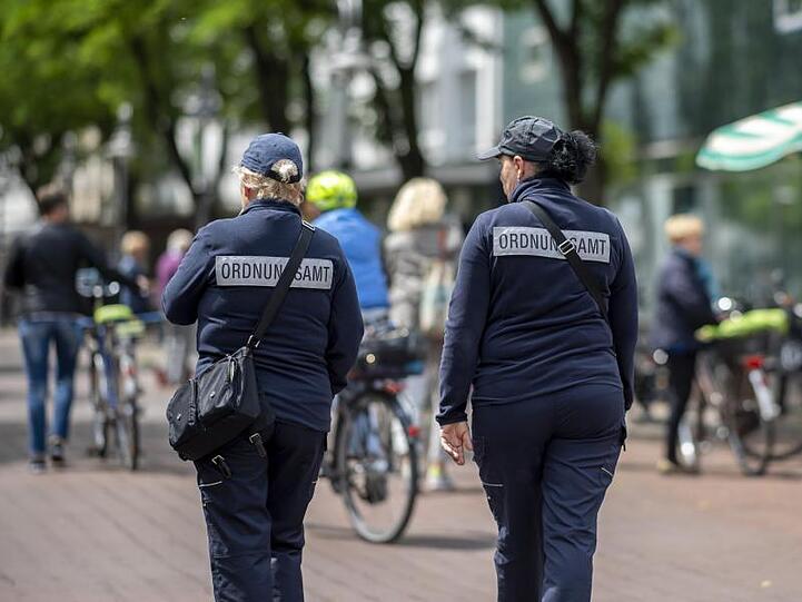 Zwei Mitarbeiterinnen vom Ordnungsamt kontrollieren in der Berliner Straße in der Innenstadt von Güterloh.