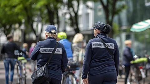 Zwei Mitarbeiterinnen vom Ordnungsamt kontrollieren in der Berliner Straße in der Innenstadt von Güterloh.