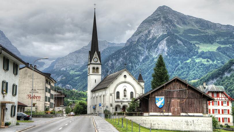 Bilderbuchlandschaft mit gefährlichen Landstraßen: Der deutschschweizer Kanton Glarus, wo der im Buch zentrale tödliche Autounfall 1963 wirklich geschah. Bilderbuchlandschaft mit gefährlichen Landstraßen: Der deutschschweizer Kanton Glarus, wo der im Buch zentrale tödliche Autounfall 1963 wirklich geschah.