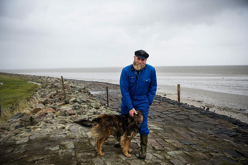 Postschiffer Fiede Nissen steht mit seinem Hund Bonnie auf der nordfriesischen Hallig Langeneß