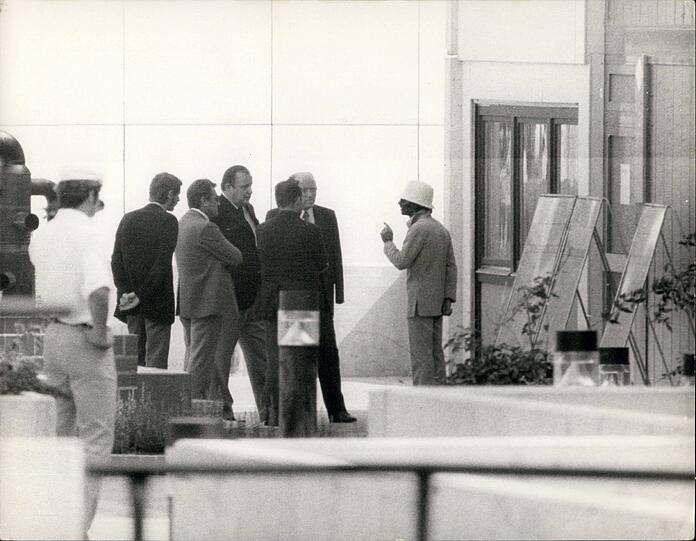 1972 im Olympiadorf: Einer der Geiselnehmer (mit weißem Hut) verhandelt mit Innenminister Dietrich Genscher (3. v. r.) und Polizeipräsident Manfred Schreiber (3. v. l.).