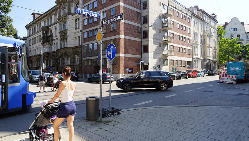 Eine Mutter versucht, mit Kinderwagen die belebte Thierschstraße zu überqueren – kein einfaches Unterfangen bei Tram und schnellen Autos. Eine Mutter versucht, mit Kinderwagen die belebte Thierschstraße zu überqueren – kein einfaches Unterfangen bei Tram und schnellen Autos.