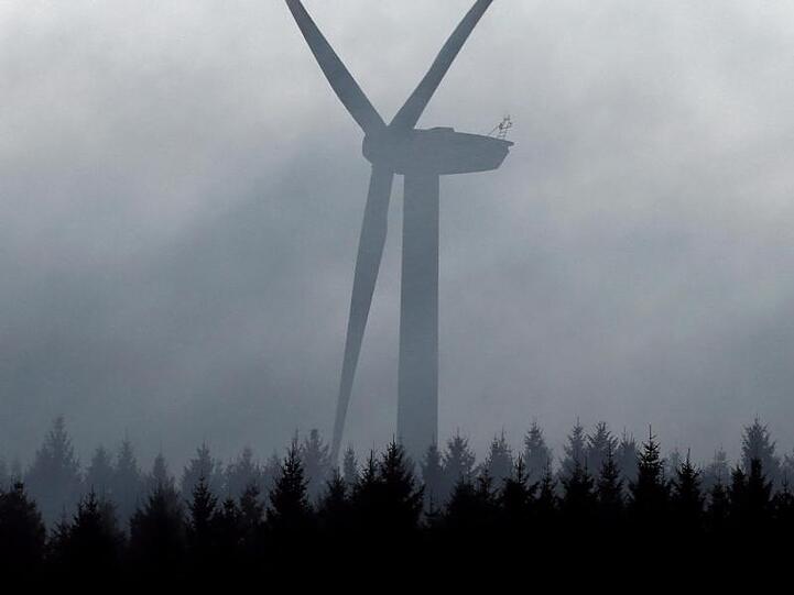 Ein Windrad ragt bei Kraftisried (Bayern) aus dem Nebel. Foto: Karl-Josef Hildenbrand/Archiv
