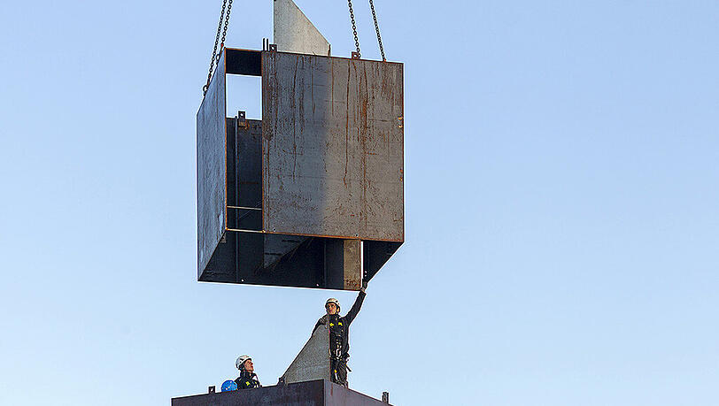 Die Skulptur besteht aus 13 stählernen Kuben, die jeweils um 90° gedreht übereinander positioniert sind. Die Skulptur besteht aus 13 stählernen Kuben, die jeweils um 90° gedreht übereinander positioniert sind.