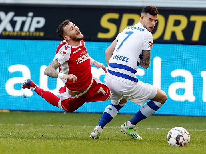 Duisburgs Andreas Wiegel (r) bringt den Berliner Marcel Hartel zu Fall.