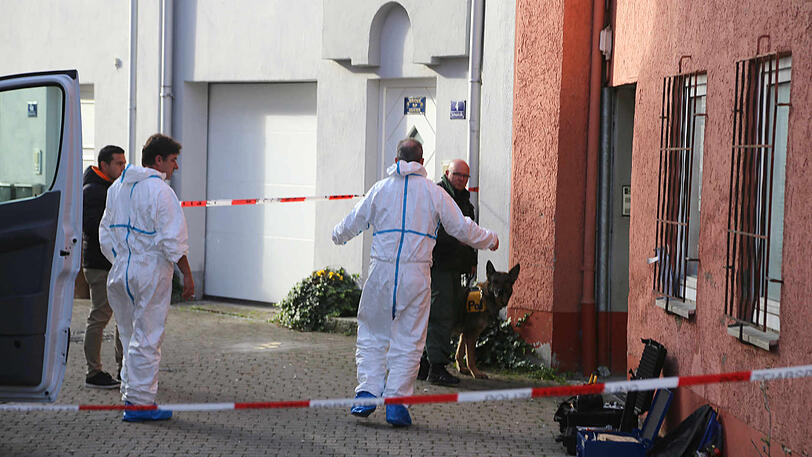 Polizisten durchsuchen eine Wohnung, nachdem die Leiche der Frau gefunden wurde.
