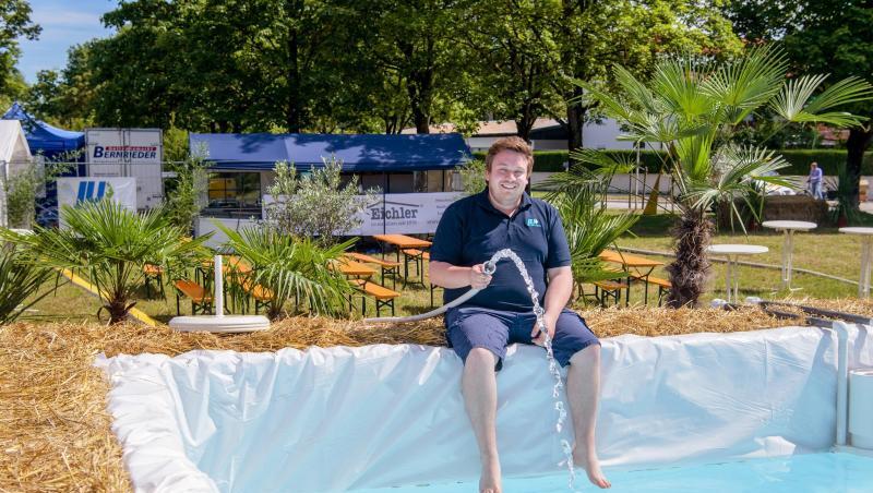 Florian Pöhlmann, Ortsvorsitzender der Jungen Union in Vaterstetten, lässt Wasser aus einem Schlauch in einen Strohballen-Pool laufen. Foto: Matthias Balk Florian Pöhlmann, Ortsvorsitzender der Jungen Union in Vaterstetten, lässt Wasser aus einem Schlauch in einen Strohballen-Pool laufen. Foto: Matthias Balk