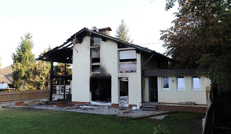 Blick auf die verkohlte Villa des Bayern-Stars Breno: Auch nach Tagen stehen noch Dienstfahrzeuge der Polizei vor dem Anwesen in Grünwald