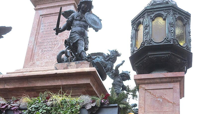 Ein Regenschirm - malerisch drapiert an der Mariensäule Ein Regenschirm - malerisch drapiert an der Mariensäule