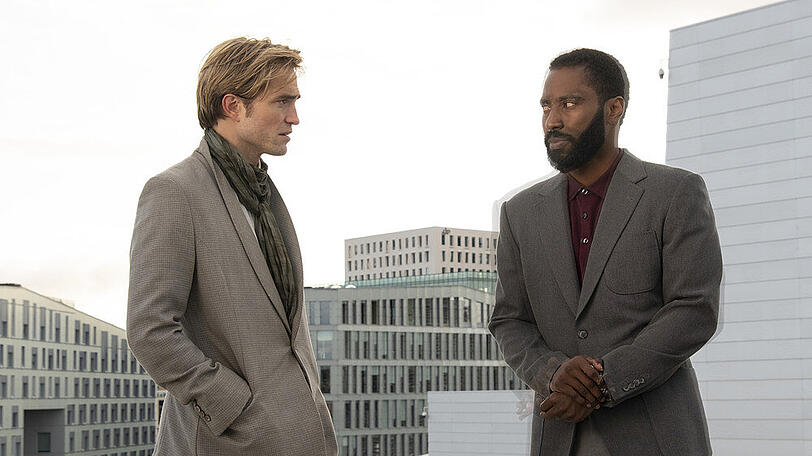 John David Washington (r.) und Robert Pattinson verspäten sich etwas zum Kino-Reboot.