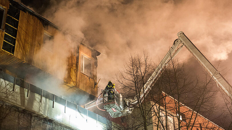 Feuerwehrleute löschen am 17.12.2017 in Hamburg ein brennendes Holz-Penthaus, das auf einem Bunker aus dem Zweiten Weltkrieg steht. Mit rund 100 Einsatzkräften war die Feuerwehr vor Ort, um den Brand zu löschen und an den Brandherd zu gelangen, wie ein Feuerwehr-Sprecher berichtete. Verletzte habe es nicht gegeben.