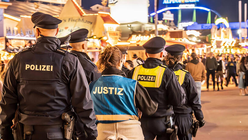 Polizisten abends auf dem Oktoberfestgelände, eine Justizbedienstete begleitet die Streife. (Symbolbild) Polizisten abends auf dem Oktoberfestgelände, eine Justizbedienstete begleitet die Streife. (Symbolbild)